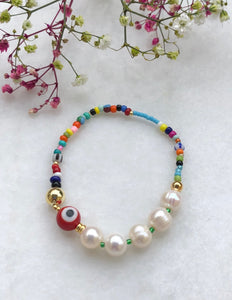 Armbånd med fargerike perler , runde barokk ferskvanns perler og en rød evil eye perle